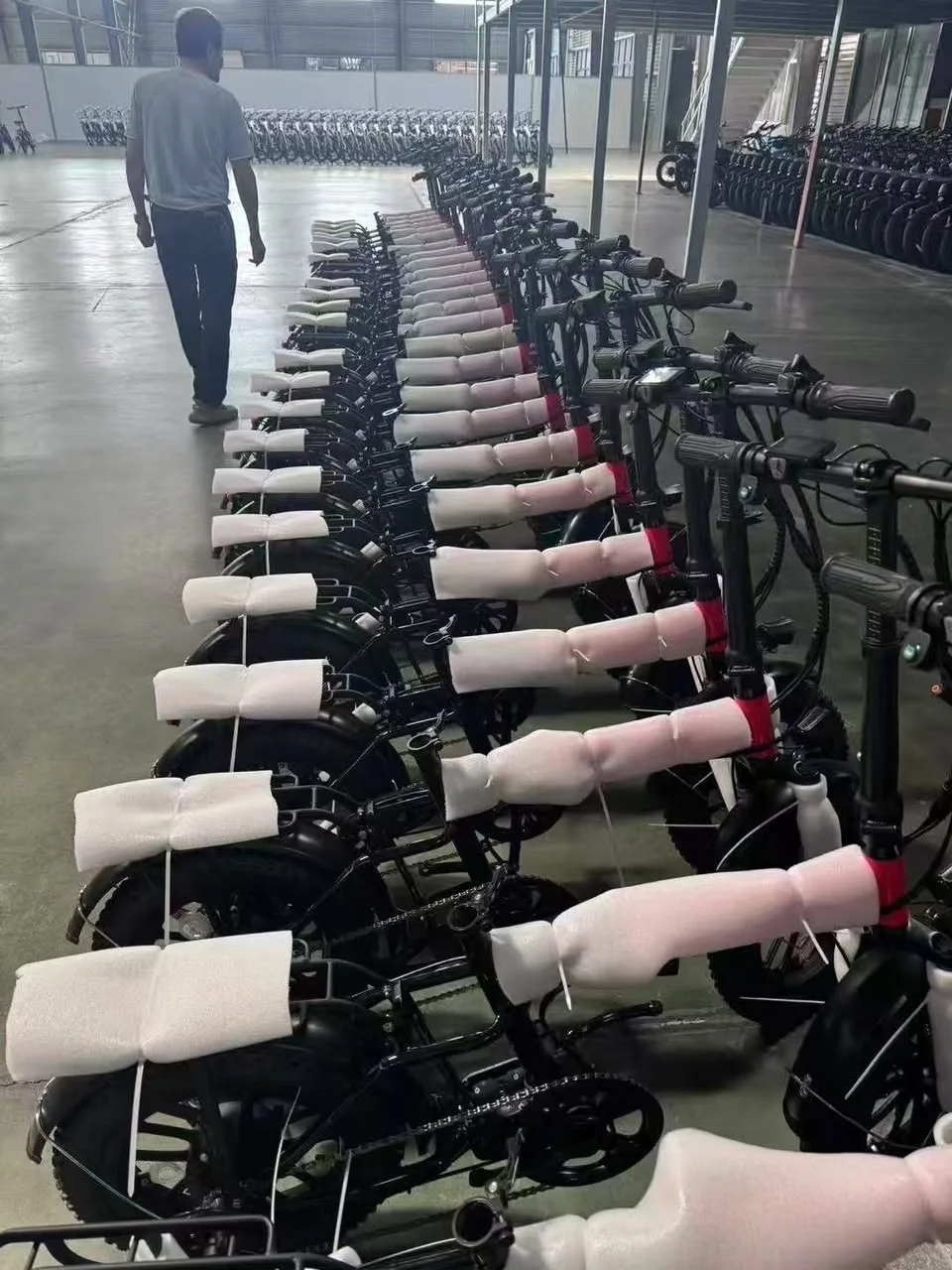 Rows of two-wheel vehicles in an indoor facility.