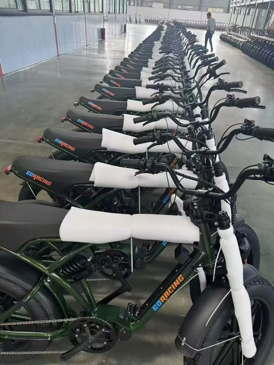 Rows of two-wheel vehicles in an indoor facility.